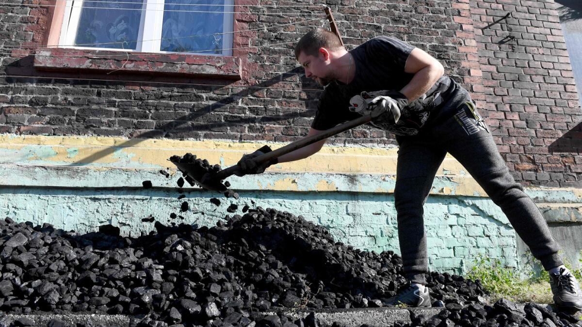 A miner throws coal into the basement of a house in Mikolow, Poland, in October.