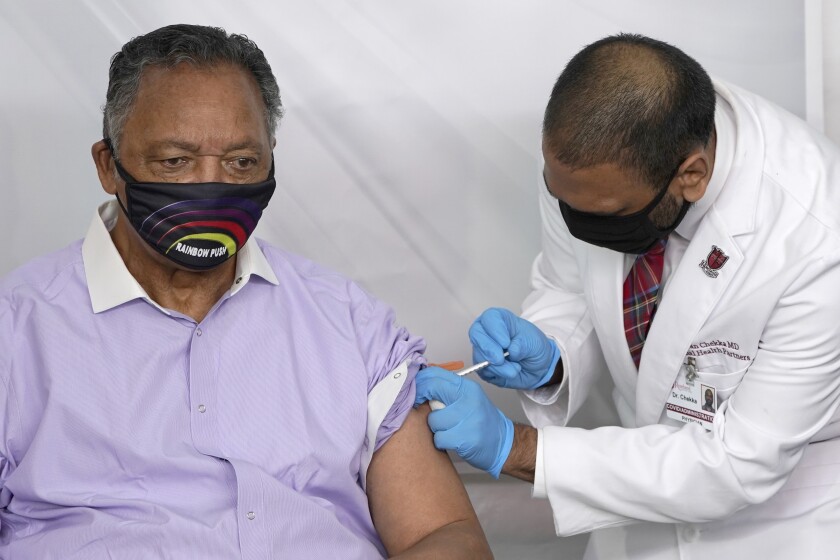 The Rev. Jesse Jackson is vaccinated in Chicago in January by Dr. Kiran Chekka.