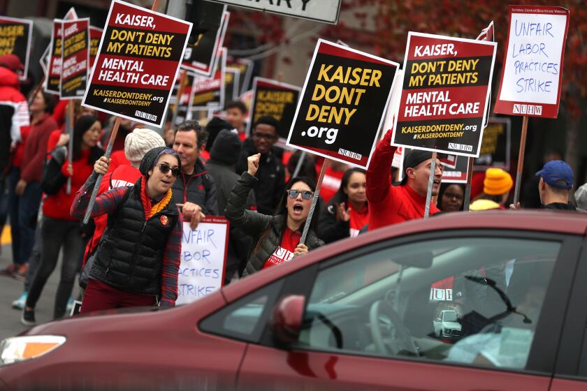 SAN FRANCISCO, CALIFORNIA - DECEMBER 10: Kaiser Permanente mental health workers carry signs as they march in front of Kaiser Permanente San Francisco Medical Center on December 10, 2018 in San Francisco, California. Nearly 4,000 Kaiser Permanente mental health workers with the National Union of Healthcare Workers union kicked off a five-day strike at Kaiser facilities throughout California. The union says that they are protesting the lack of staffing that forces many patients to wait for a month or more for appointments. (Photo by Justin Sullivan/Getty Images)