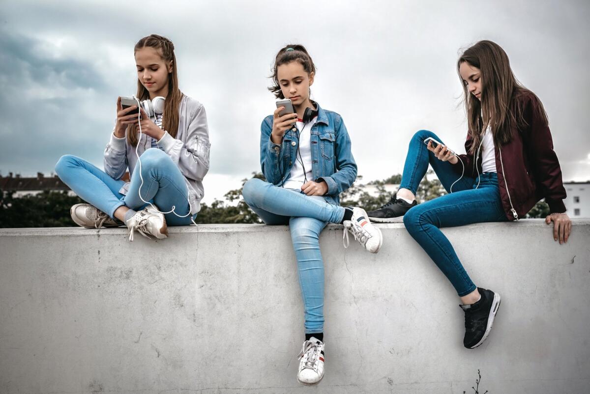 Adolescentes constantemente conectadas a sus teléfonos y redes sociales.