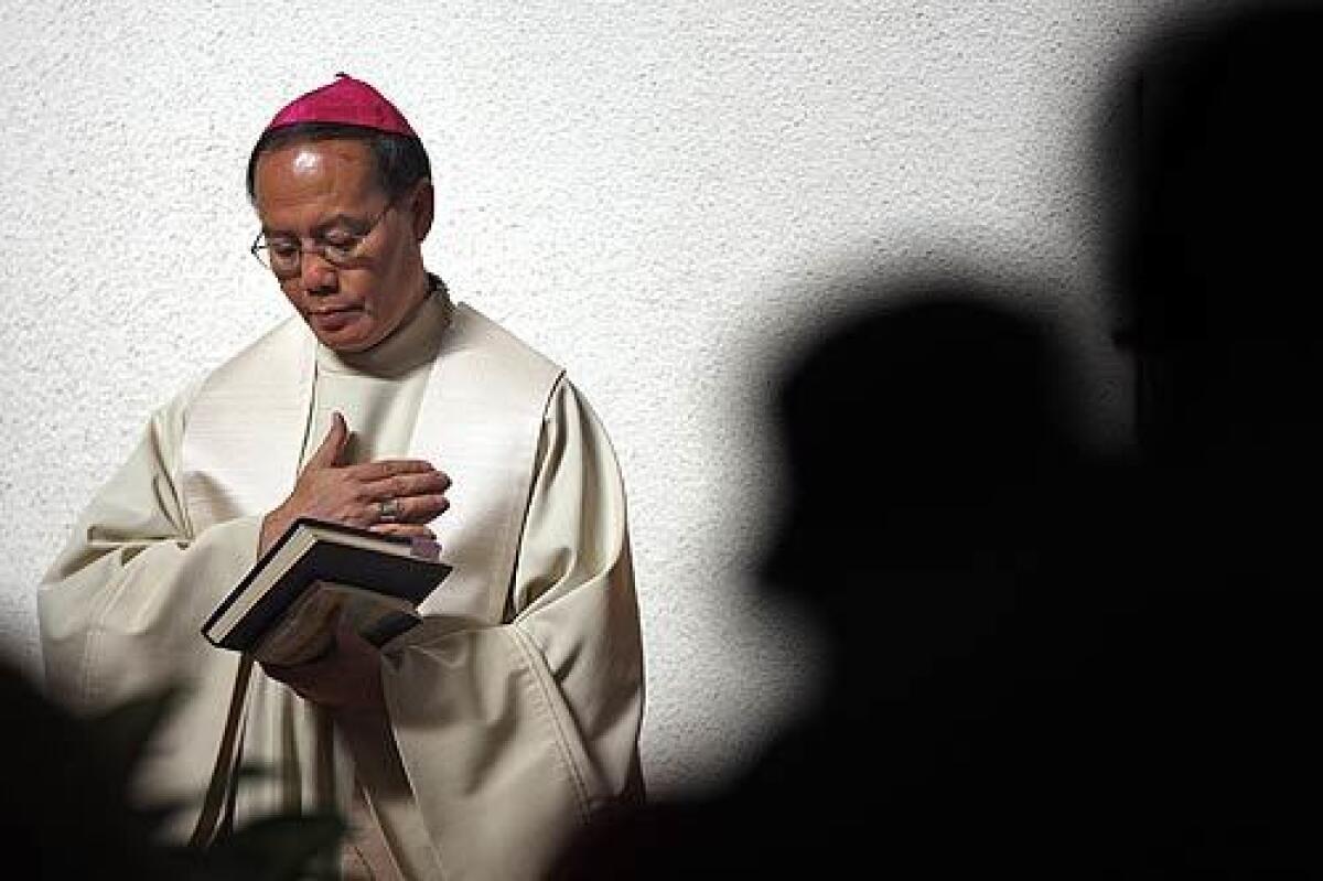 Archbishop Joseph Kiet Ngo, of the Archdiocese of Hanoi, listens to a reading from the Bible during Mass at the Holy Family Cathedral in Orange .