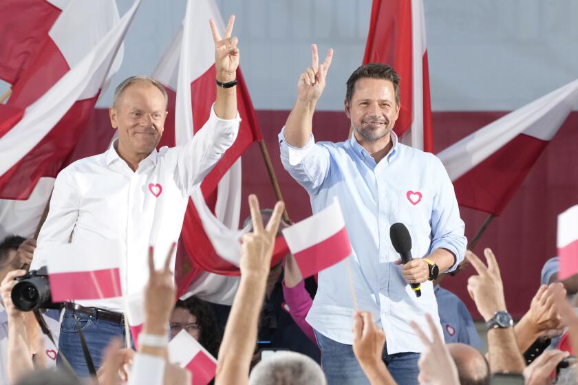 Poland's opposition leader and former prime minister, Donald Tusk, left, and his Civic Platform member, Warsaw Mayor Rafal Trzaskowski, right, flash victory signs during an election campaign rally in Otwock, Poland, on Monday, Sept. 25, 2023. Tusk is leading a march in Warsaw on Sunday aimed at mobilizing supporters in his against-the-odds battle to unseat the right-wing government in the Oct. 15 parliamentary election. (AP Photo/Czarek Sokolowski)
