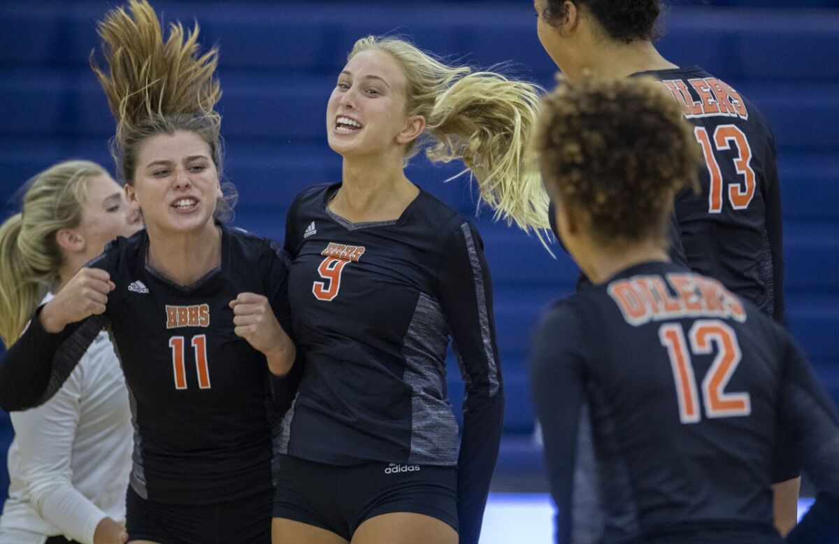 Huntington Beach's Hannah Ledesma (11), Claire Robbins (9), Olivia Carlton (13) and Xolani Hodel (12) celebrate winning a point in Game 5 of a nonleague match at Beckman on Wednesday.