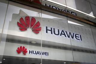 A Huawei store’s window reflects the Ministry of Foreign Affairs office in Beijing.