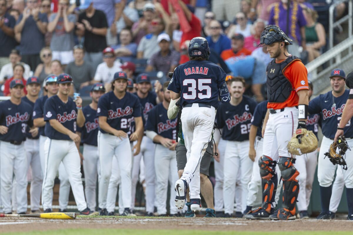 Mississippi's Kevin Graham (35) scores on his home run against Auburn during the third inning of an NCAA College World Series baseball game Saturday, June 18, 2022, in Omaha, Neb. (AP Photo/John Peterson)