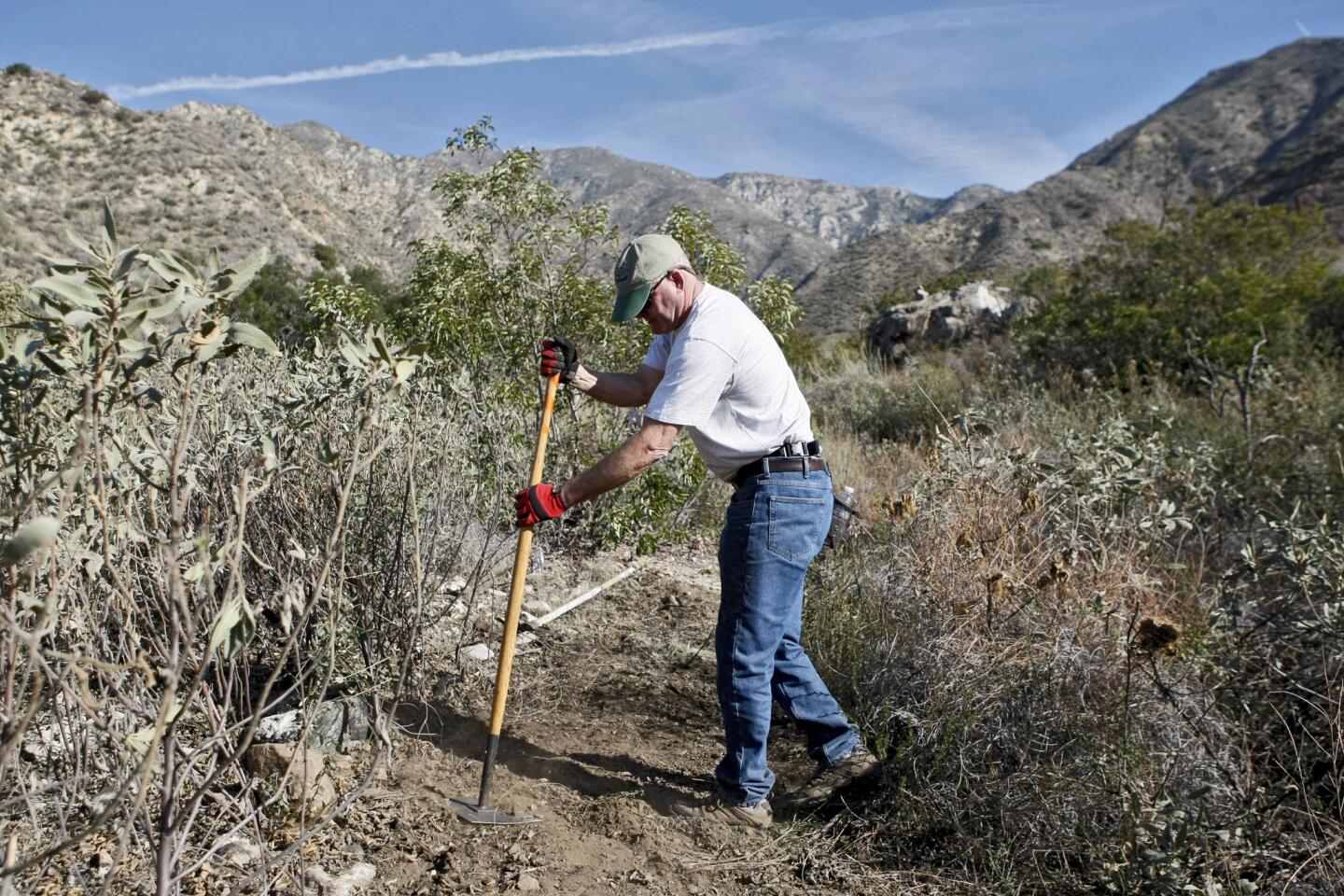 Frank Carlsen of La Crescenta helps smooth out a new trail being built by hand at Deukmejian Wilderness Park in Glendale on Saturday, January 4, 2014.