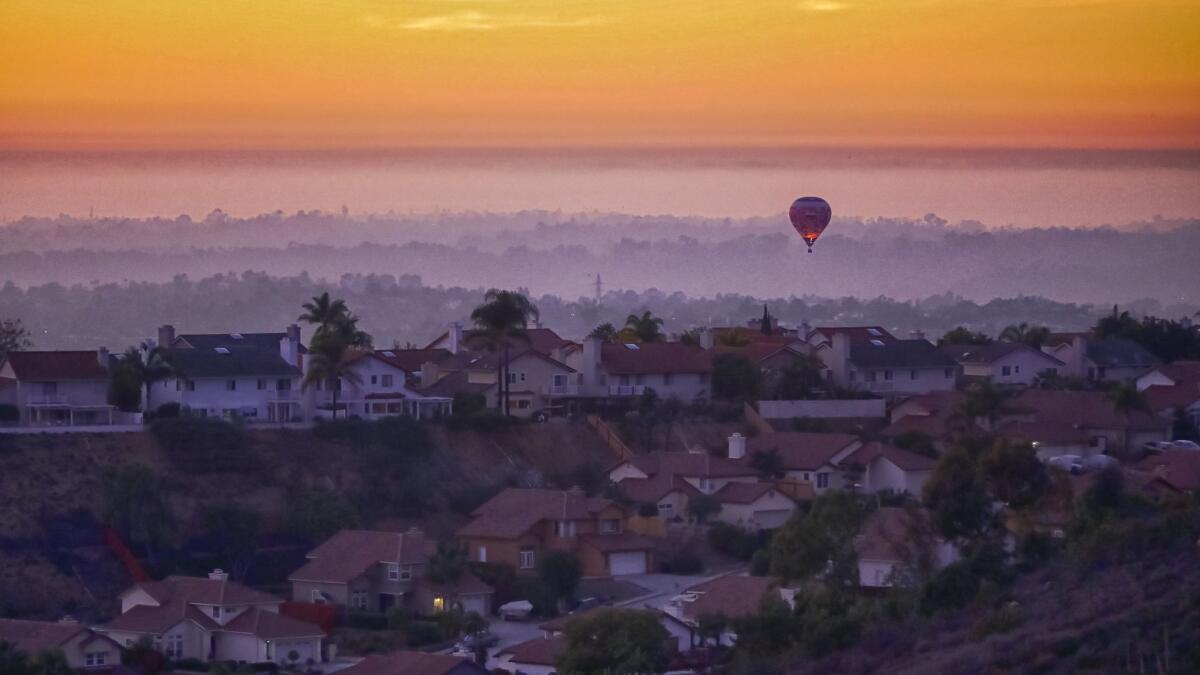 A hot air balloon flies above homes in Rancho Penasquitos a short time after sunset, Sunday evening, November 3, 2018.