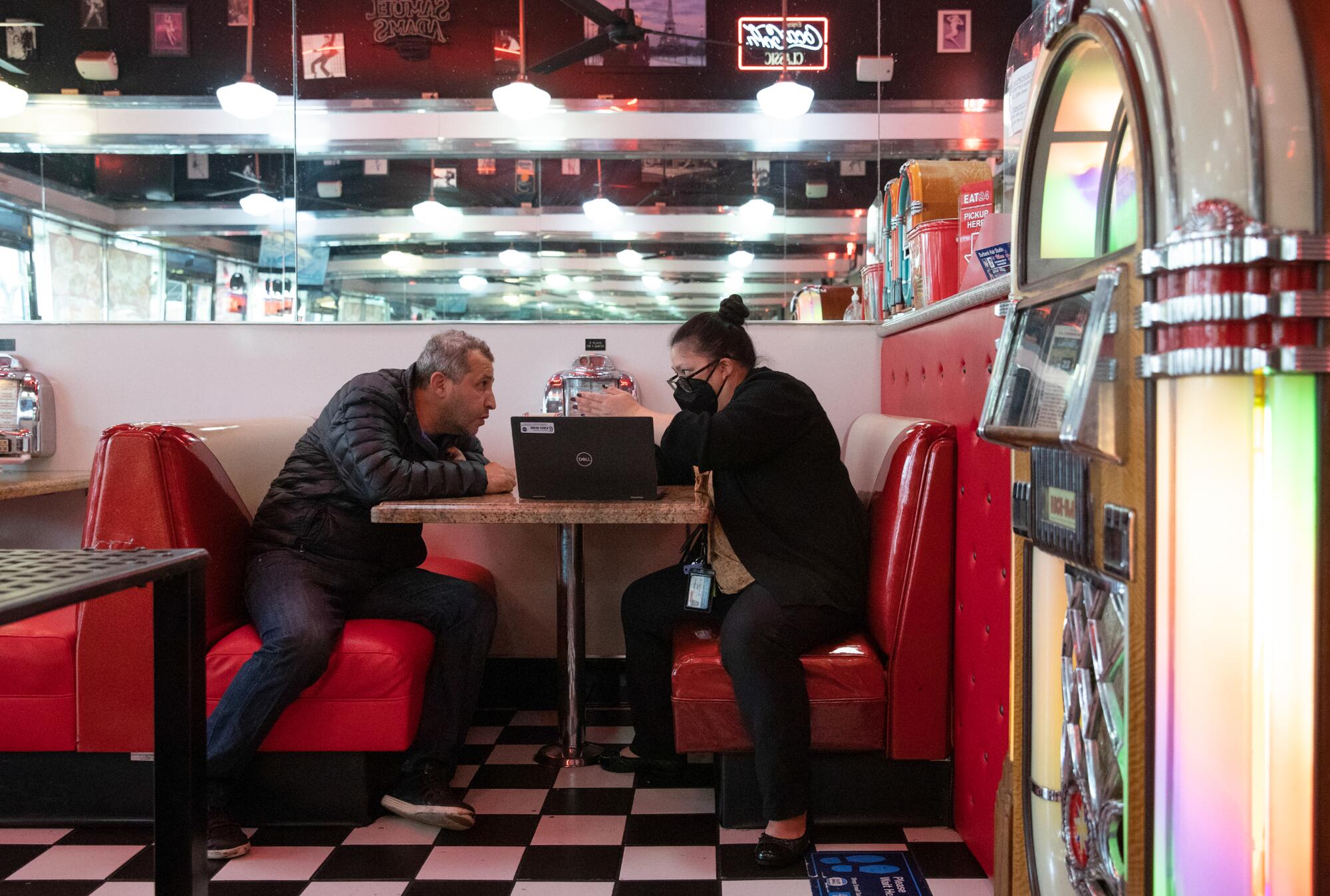 The Great Grill owner Sam Yerkanyan, left, talks with Ngoc McShane in a diner booth.