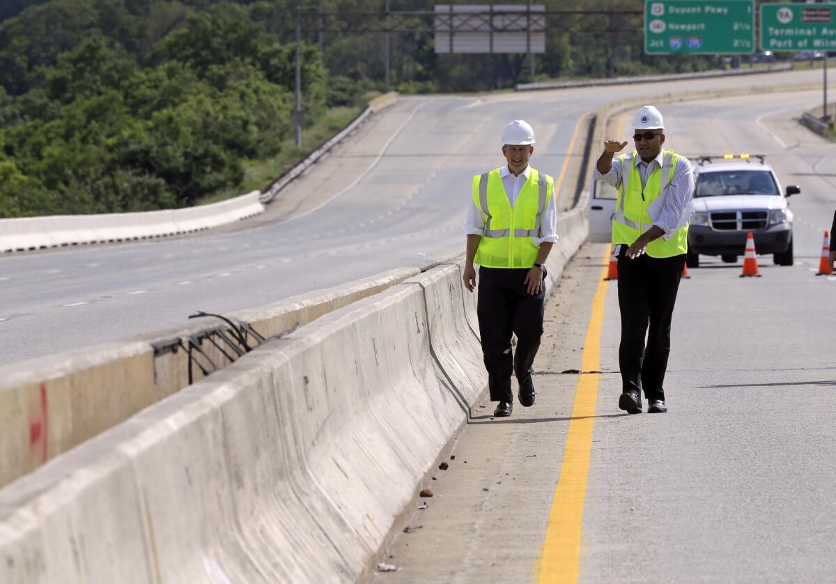Delaware Gov. Jack Markell, left, and state Department of Transportation Secretary Shailen Bhatt walk alongside barriers separating the northbound and southbound lanes of the Interstate 495 bridge over the Christina River near Wilmington, Del., on June 5. The tops of the barriers were designed to run parallel to each other.