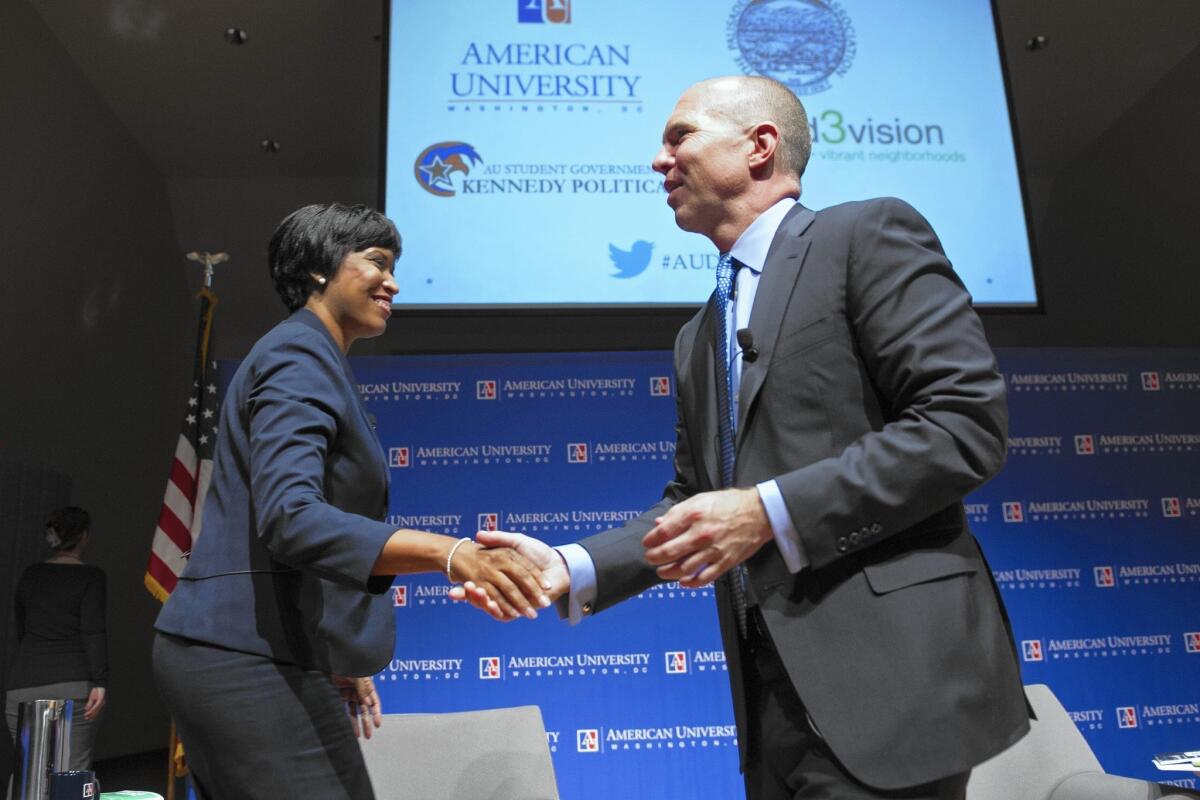 D.C. mayoral candidates Muriel Bowser and David Catania shake hands. The candidates have encountered growing concerns about the sustainability of affordable housing, good schools and a flourishing middle class in Washington.