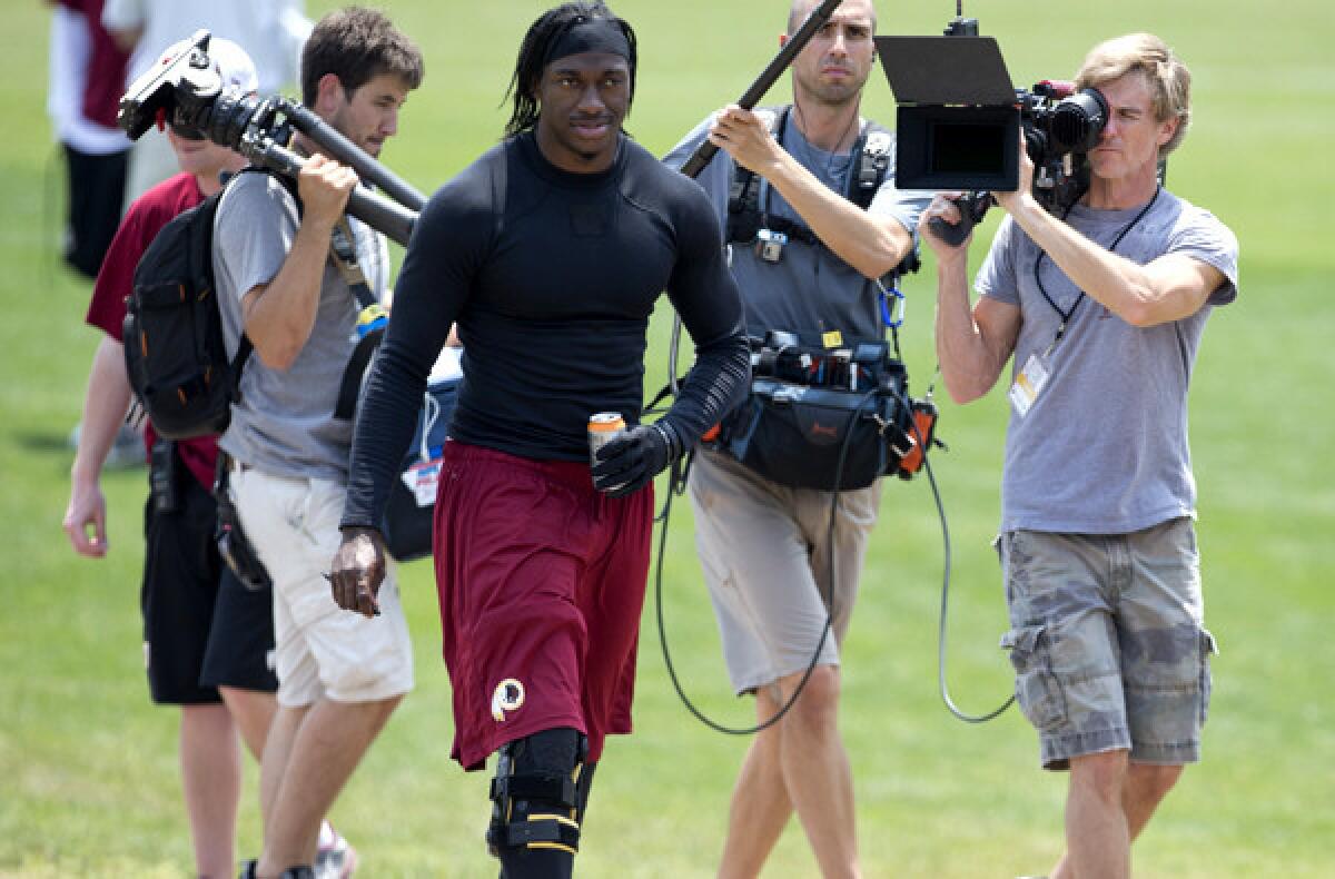 Redskins quarterback Robert Griffin III has been the center of attention as he rehabilitates his right knee this summer.