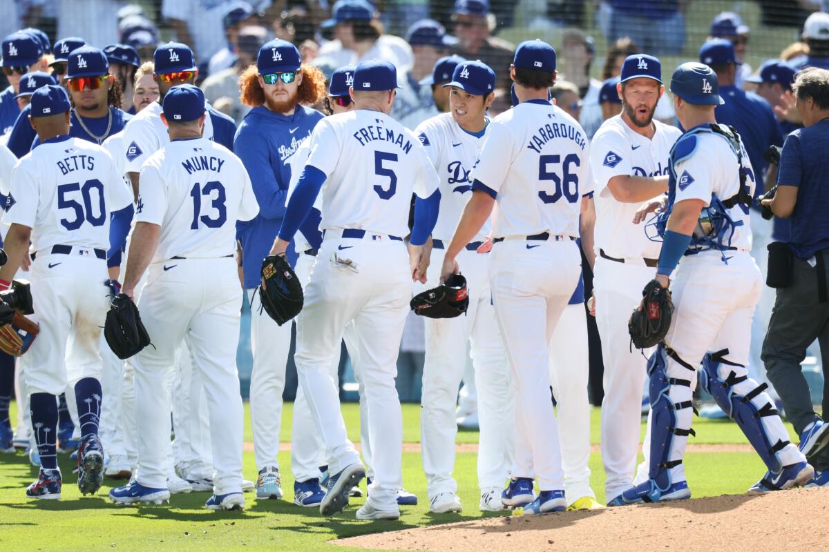 Dodgers players celebrate after defeating the St. Louis Cardinals 7-1 in their home opener Thursday at Dodger Stadium.