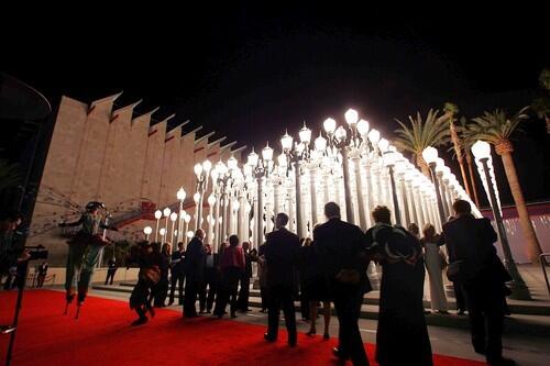 Guests take in the Urban Light installation and a dragonfly (on stilts), left, greets them as the Broad Contemporary Art Museum is unveiled at LACMA on the Miracle Mile in Los Angeles.