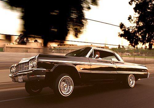 A lowrider drives along a side-street in Los Angeles.