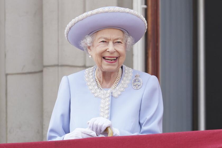 Queen Elizabeth II smiles as she watches from the balcony of Buckingham Palace in June 2022