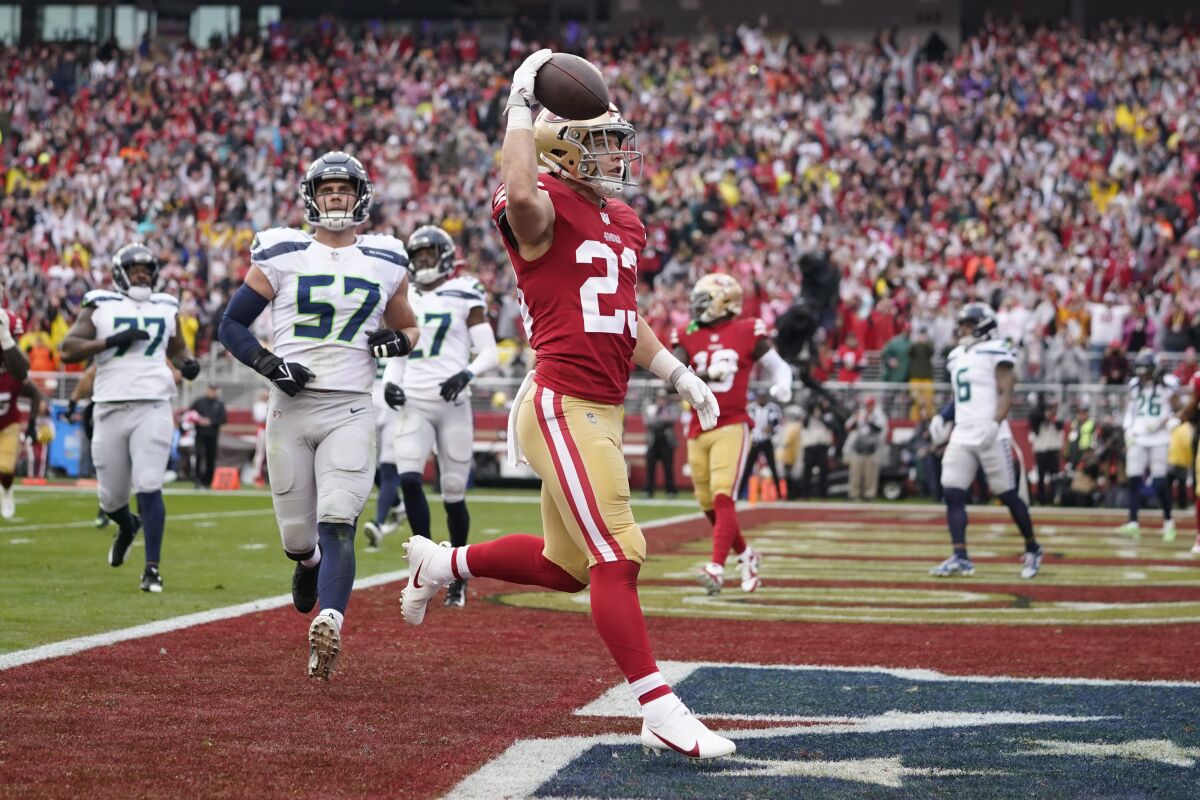 FILE - San Francisco 49ers running back Christian McCaffrey (23) celebrates after scoring a touchdown against the Seattle Seahawks during the first half of an NFL wild-card playoff football game in Santa Clara, Calif., Jan. 14, 2023. New York Giants running back Saquon Barkley, McCaffrey and Seattle Seahawks quarterback Geno Smith are the finalists for AP Comeback Player of the Year. (AP Photo/Godofredo A. Vásquez, File)