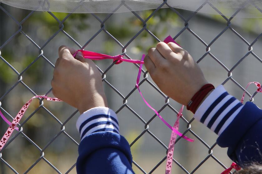 A student at Jenny Lind Elementary School ties a ribbon honoring murder victim Leila Fowler.