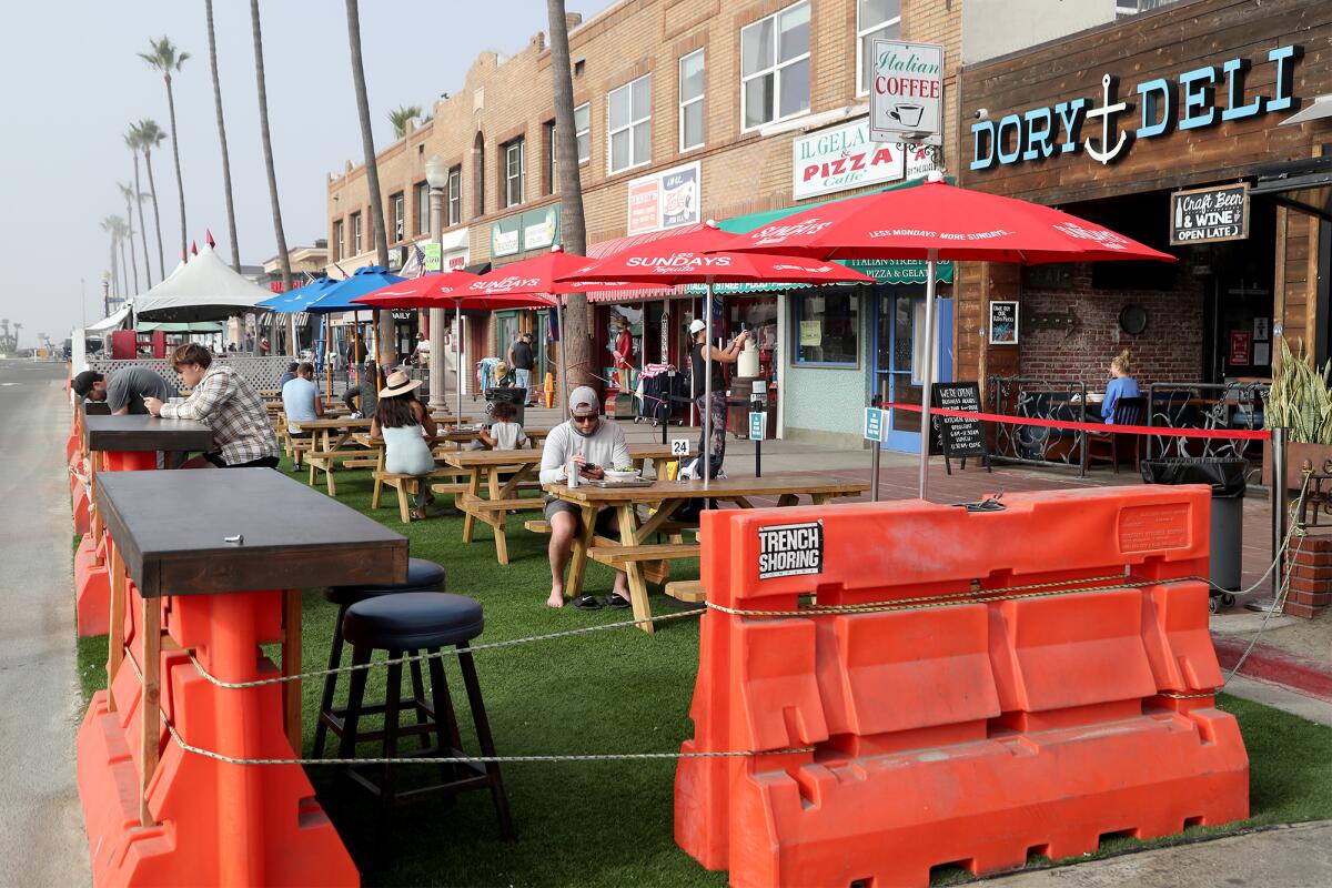 Customers sit in an outdoor dining area by Dory Deli.