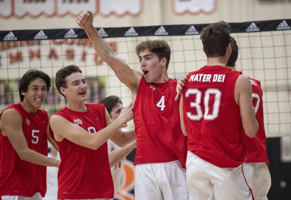 Mater Dei High's David Linkletter (4) celebrates a kill shot by teammate Joey Farney, right, in a nonleague match at Huntington Beach on Wednesday.