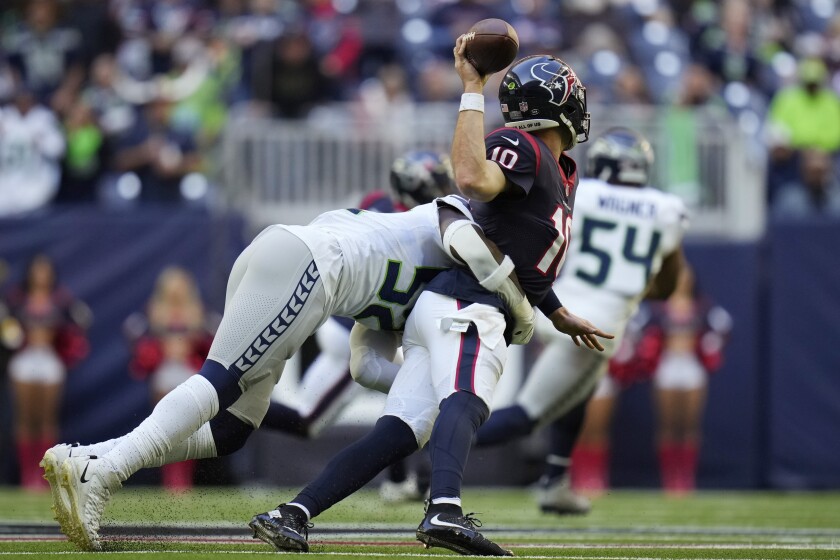 Houston Texans quarterback Davis Mills (10) is hit by Seattle Seahawks defensive end Darrell Taylor (52) as he tires to pass during the second half of an NFL football game, Sunday, Dec. 12, 2021, in Houston. (AP Photo/Eric Christian Smith)