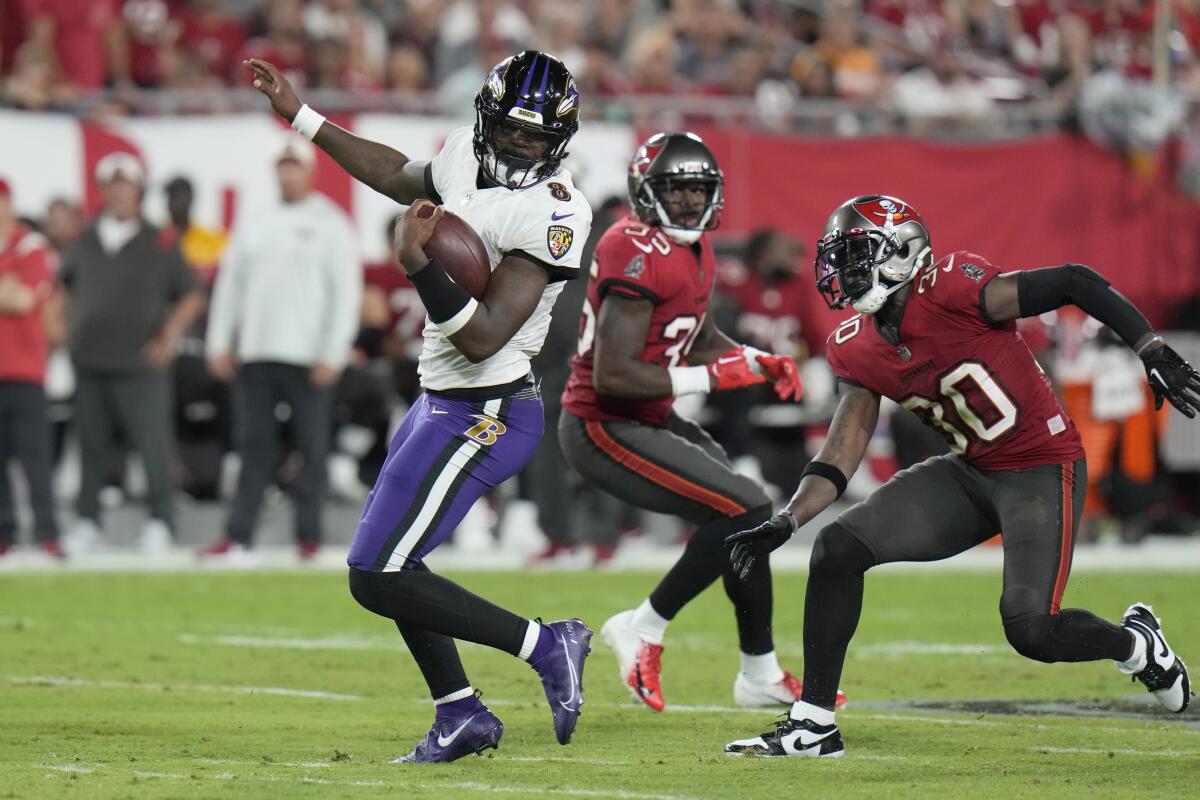 Baltimore Ravens quarterback Lamar Jackson scrambles away from Tampa Bay Buccaneers cornerback Dee Delaney.