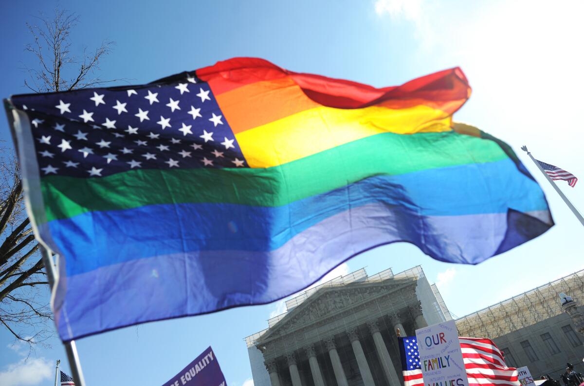 Same-sex marriage supporters wave a rainbow flag in front of the U.S. Supreme Court