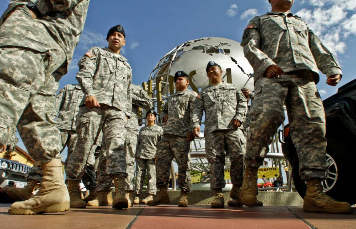 Soldiers celebrate at Universal Studios after a swearing-in ceremony. A new study finds that men who volunteer for military service are about twice as likely as other men to have had troubled childhoods.