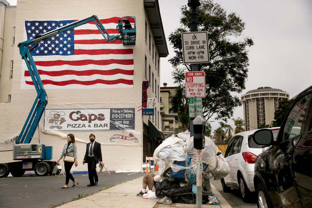 Artist David Ybarra paints an American flag on the side of Caps Pizza and Bar