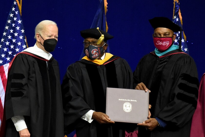 President Biden, left, helps present a diploma to U.S. House Majority Whip Jim Clyburn.