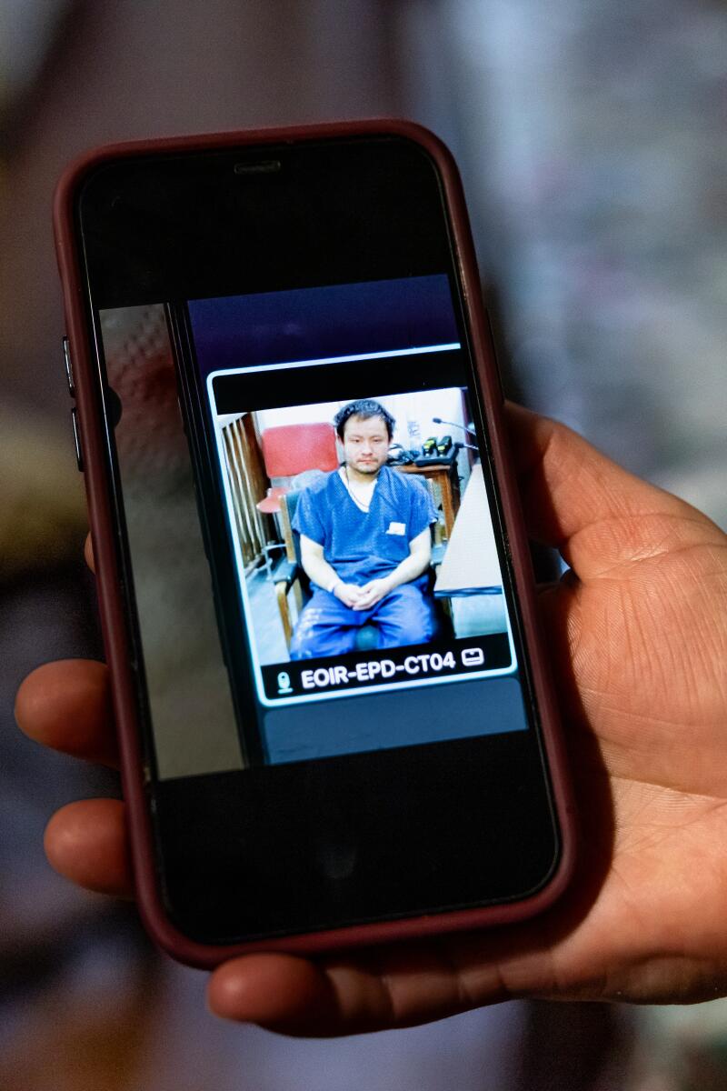 Maria Diaz shows a photograph of her son Javier, 32, in a court appearance while detained