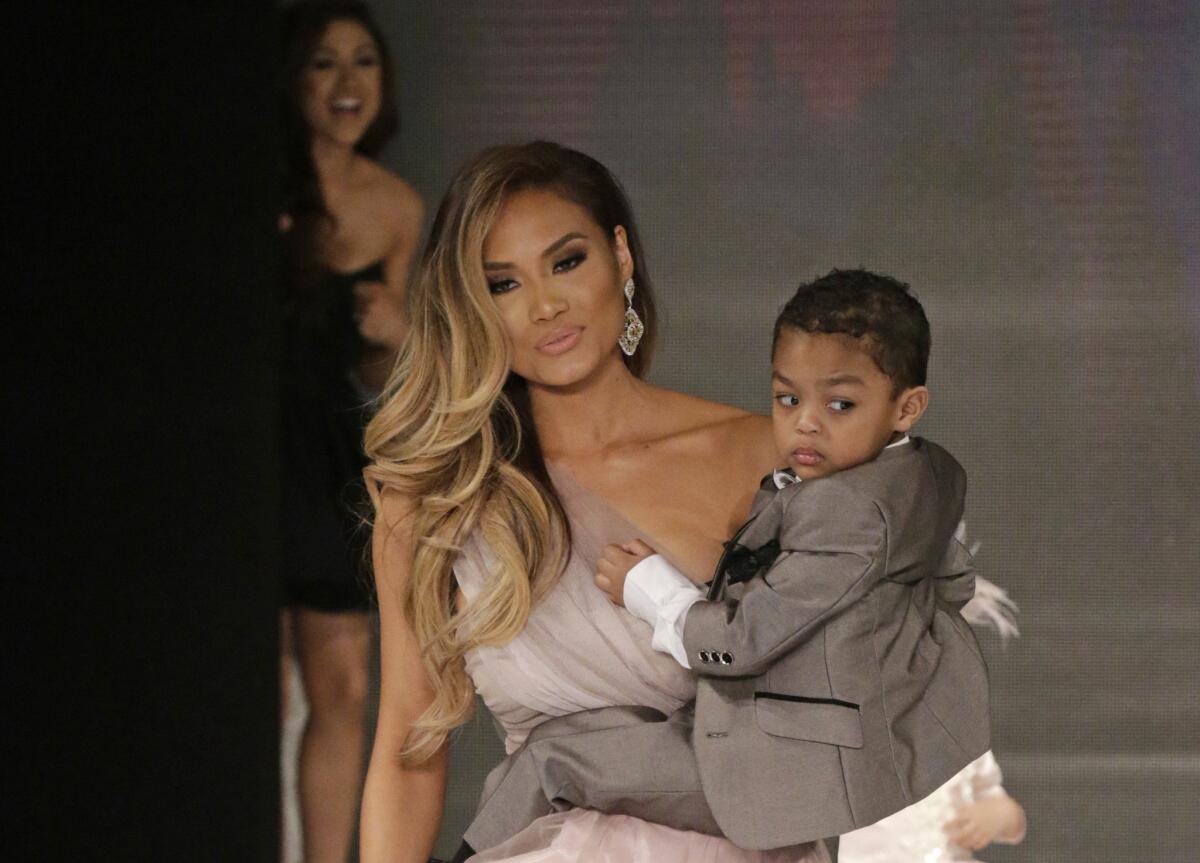 Walking the runway in the Isabella Couture show is model Daphne Joy with son Sire Jackson, whose father is 50 Cent.