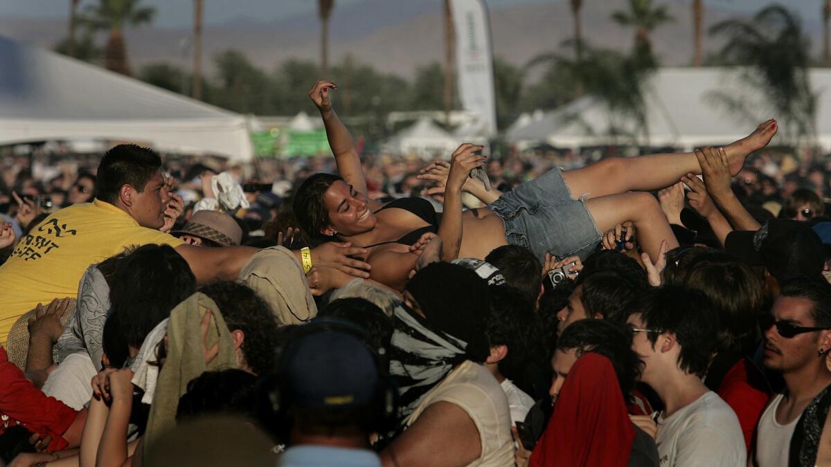 A fan is pulled from the crowd during the Arcade Fire performance at Coachella 2007