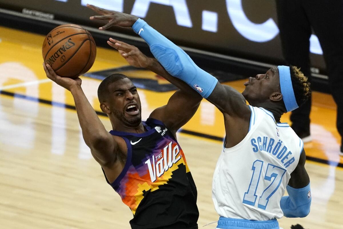 Lakers guard Dennis Schroder tries to block a shot by Suns guard Chris Paul during a game in 2021.