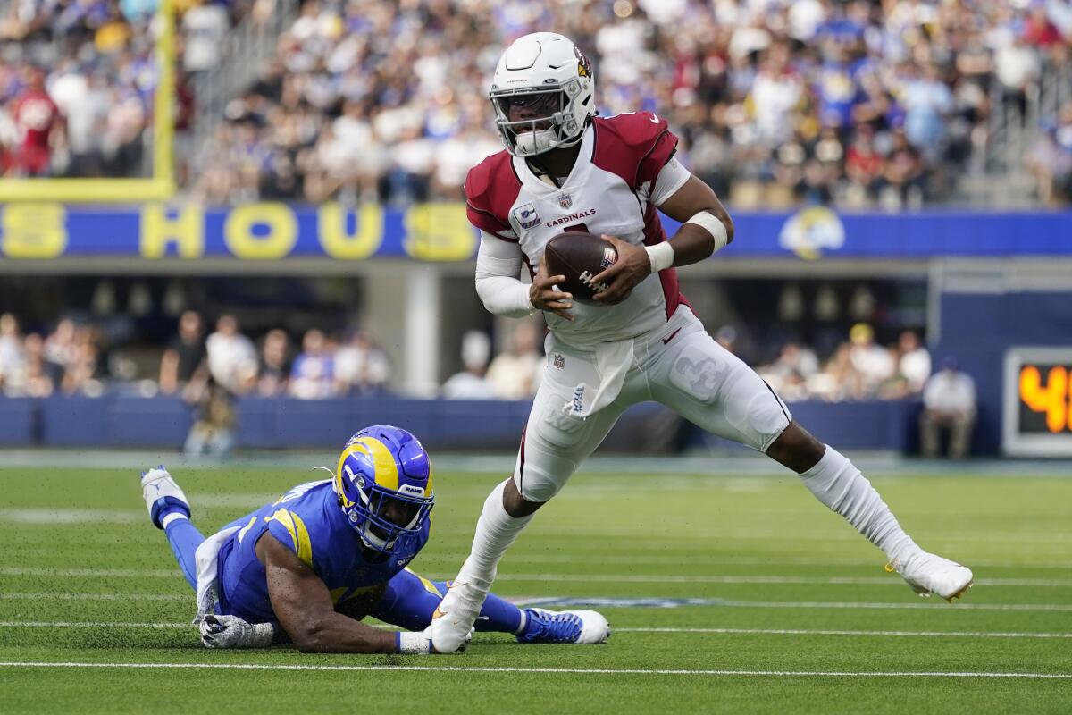 Arizona Cardinals quarterback Kyler Murray evades the tackle attempt by Rams linebacker Obo Okoronkwo.