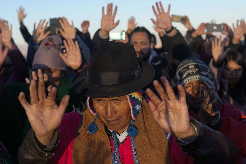 Los indígenas aymaras reciben los primeros rayos de sol en un ritual de Año Nuevo en la montaña Murmutani en las afueras de Hampaturi, Bolivia, la madrugada del miércoles 21 de junio de 2023. (AP Foto/Juan Karita)