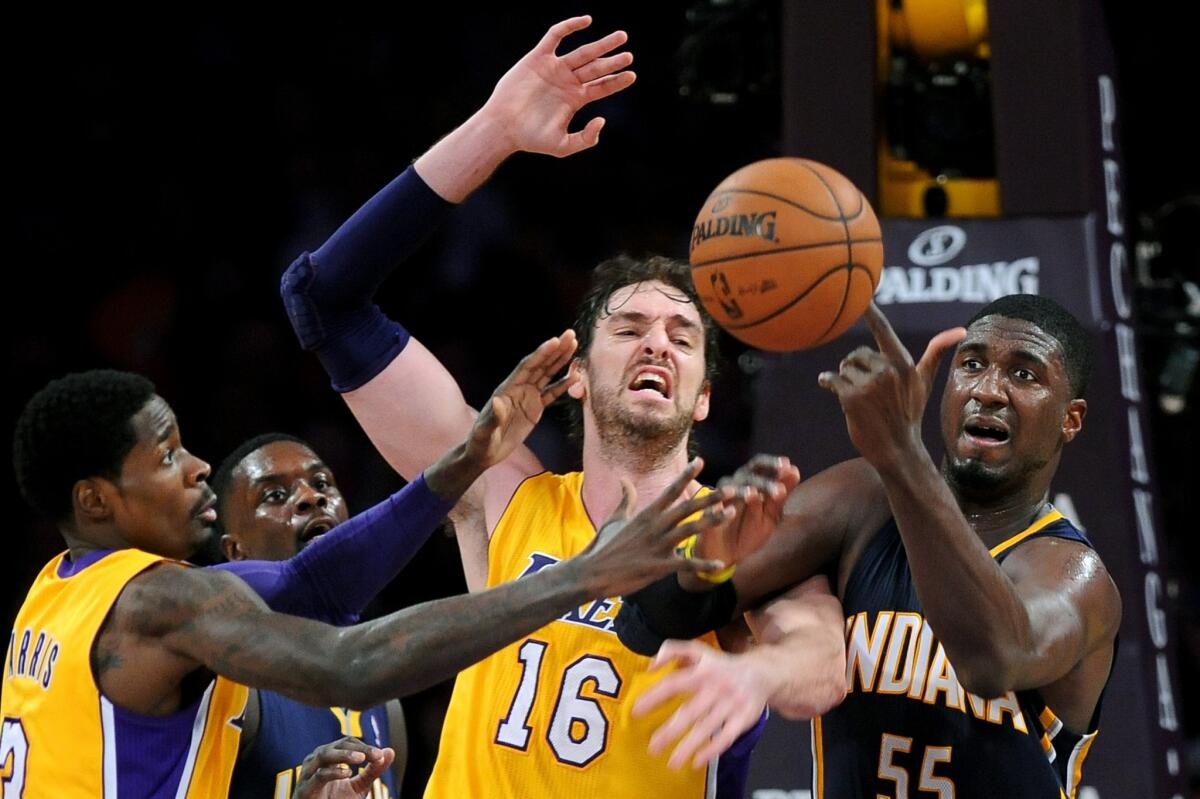 Lakers teammates Manny Harris, left, and Pau Gasol, middle, battle Indiana Pacers center Roy Hibbert for a rebound during the Lakers' 104-92 loss Tuesday at Staples Center.