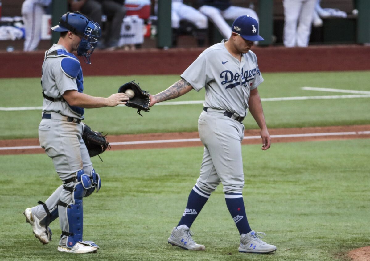 Dodgers catcher Will Smith hands the ball to pitcher Julio Urías during Game 3 of the NLCS.