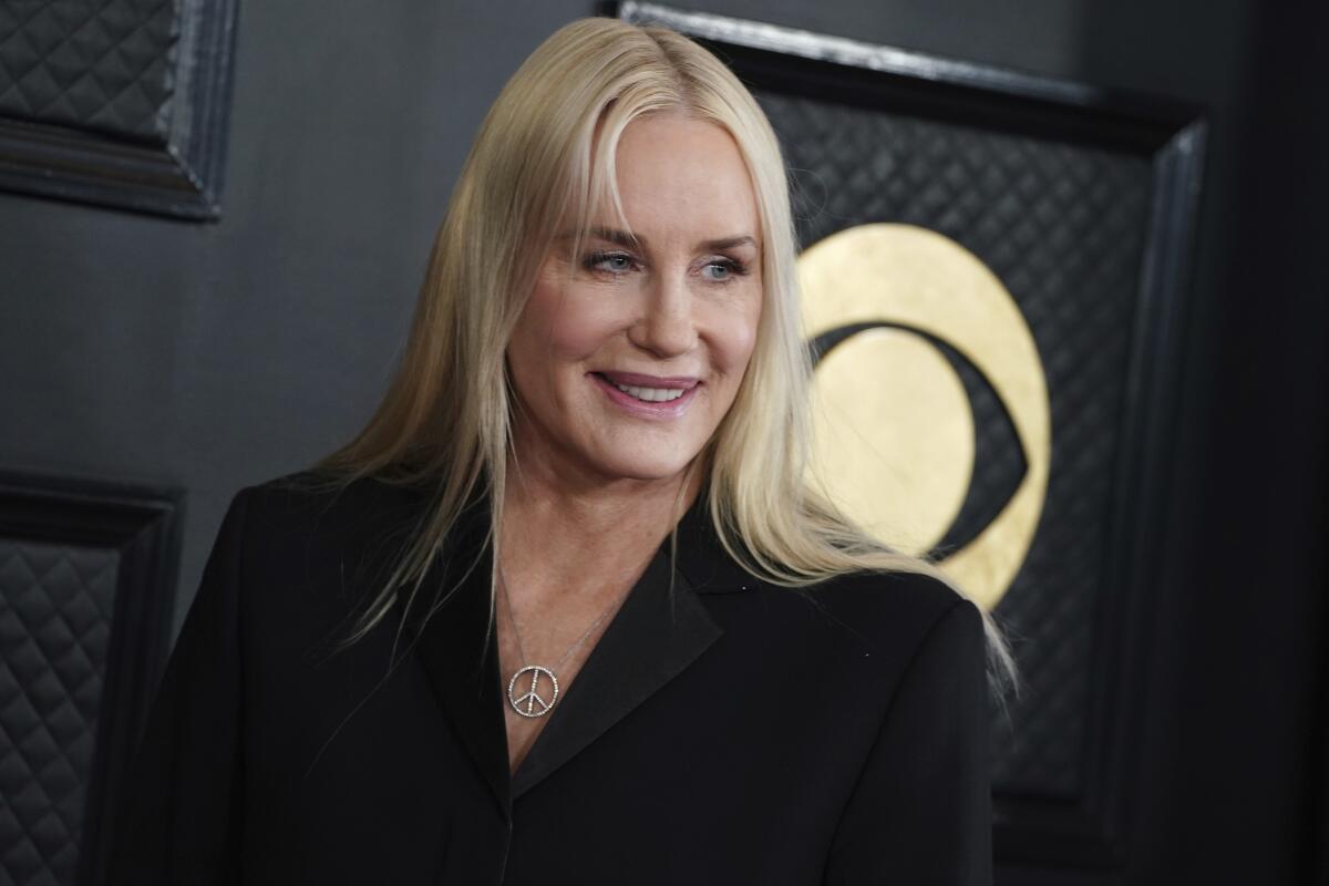 Daryl Hannah arrives at the Grammy Awards, dressed in black and wearing a peace sign necklace.