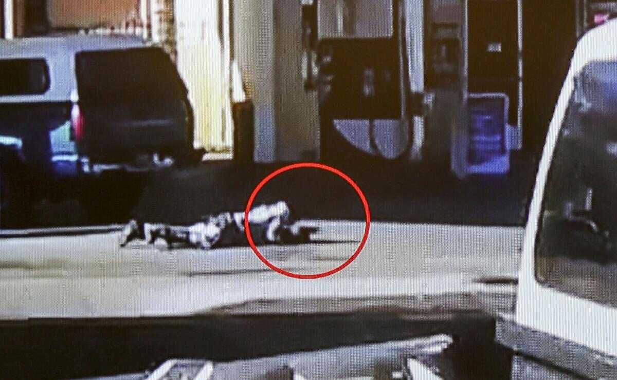 In this image made from security video footage provided by the Los Angeles County Sheriff, Nicholas Robertson is stretched out on the ground with a gun in his hand after he was shot by Los Angeles deputies on Dec. 12 in Lynwood.