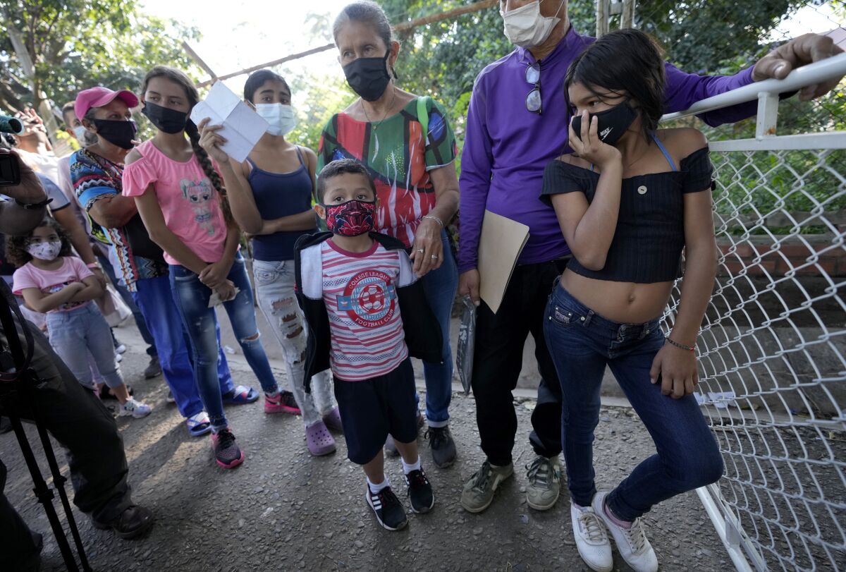 Venezuelans citizen wait in line to receive a dose of a COVID-19 vaccine in La Parada, near Cucuta, Colombia, Friday, Nov. 12, 2021. Over the past two weeks Colombia has provided COVID-19 vaccines to thousands of Venezuelans. (AP Photo/Fernando Vergara)