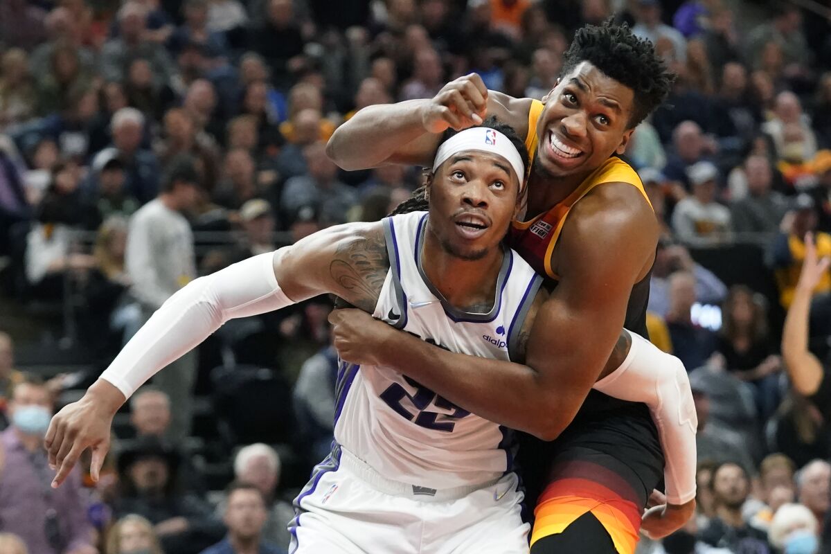 Utah Jazz center Hassan Whiteside, right, and Sacramento Kings center Richaun Holmes (22) vie for position under the boards during the second half of an NBA basketball game Tuesday, Nov. 2, 2021, in Salt Lake City. (AP Photo/Rick Bowmer)