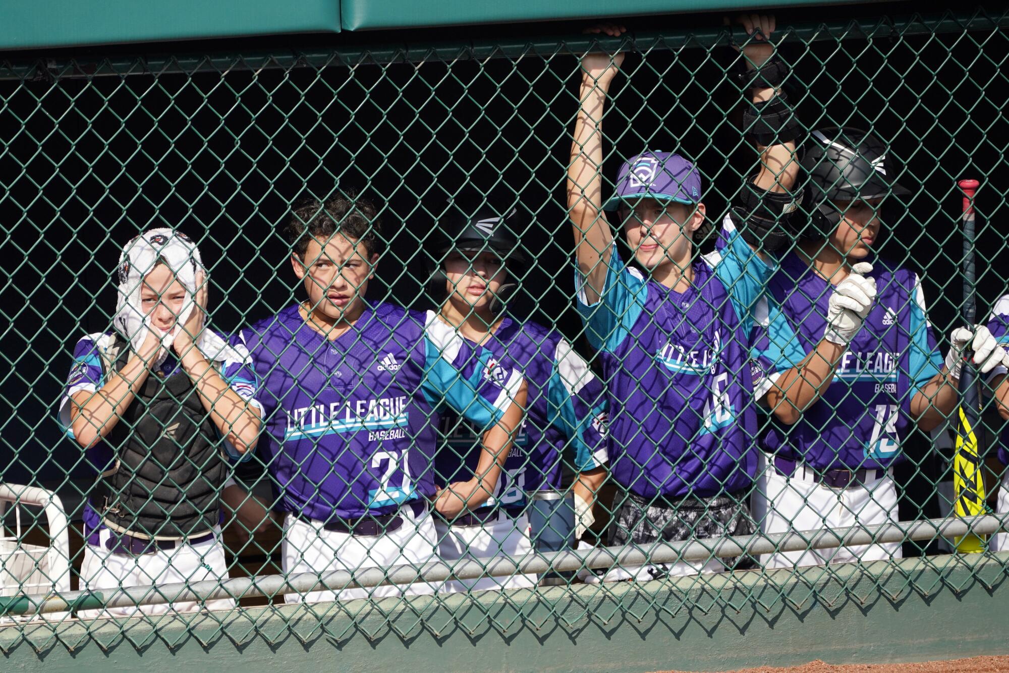 Ella Bruning, left, watches from the dugout with Dylan Regata, Landry Pate, Blaze Ruffin and Major De Los Santos