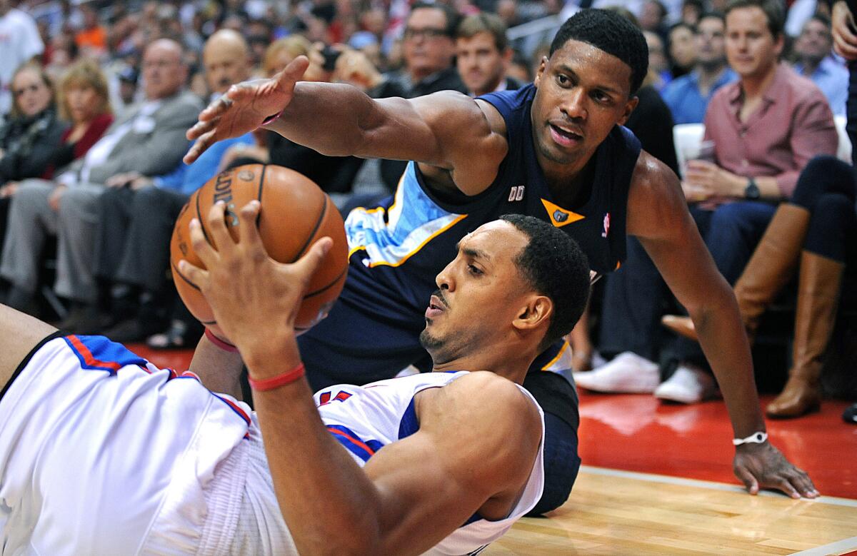 The Clippers' Ryan Hollins (with the ball) is fouled by the Grizzlies' Rudy Gay during a scramble for a loose ball at Staples Center.