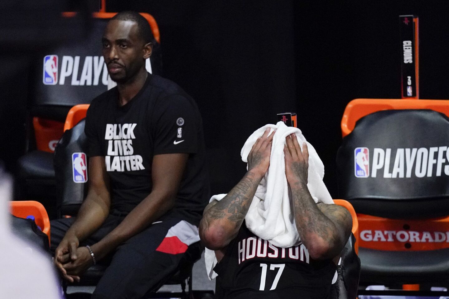 Houston's P.J. Tucker puts a towel over his face next to Luc Mbah a Moute during the second half.