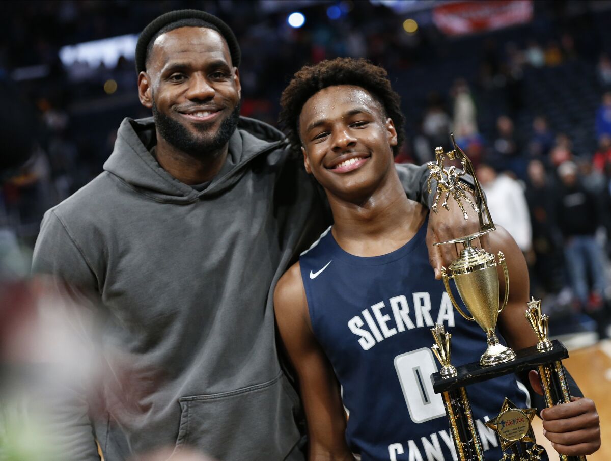 LeBron James poses for photos with son Bronny after Sierra Canyon High defeated the Lakers' star's alma mater on Dec. 14, 2019, in Columbus, Ohio.