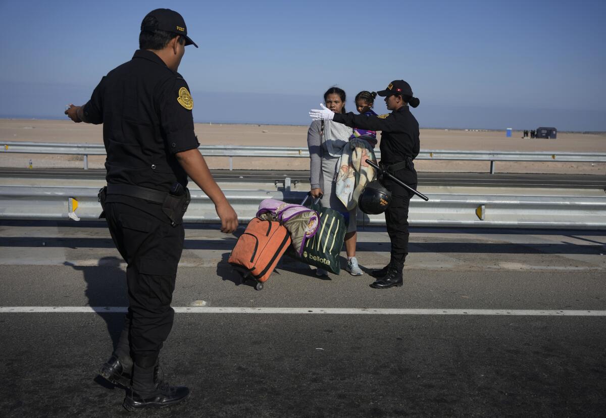 Migrantes son escoltados por la policía peruana para regresar a la frontera con Chile, en Tacna, Perú