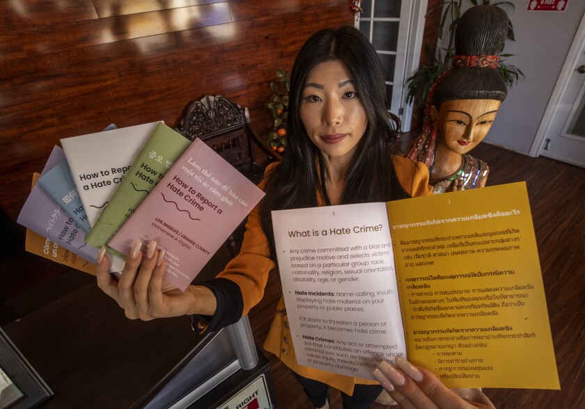 A woman holds up booklets with her hands.