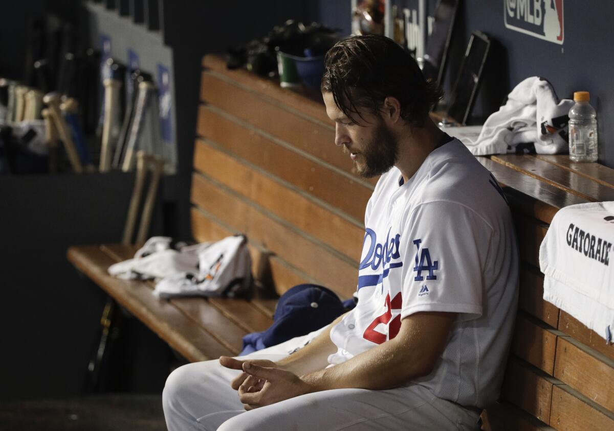 El lanzador de los Dodgers de Los Ángeles, Clayton Kershaw, permanece pensativo en el dugout durante el séptimo inning del quinto juego de la Serie Mundial contra los Medias Rojas de Boston, el domingo 28 de octubre de 2018, en Los Ángeles.