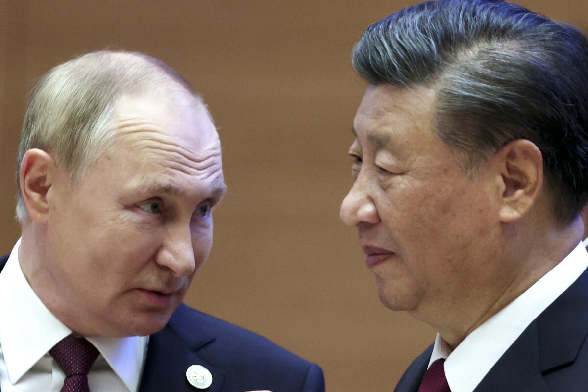 Russian President Vladimir Putin, left, speaks to Chinese President Xi Jinping 