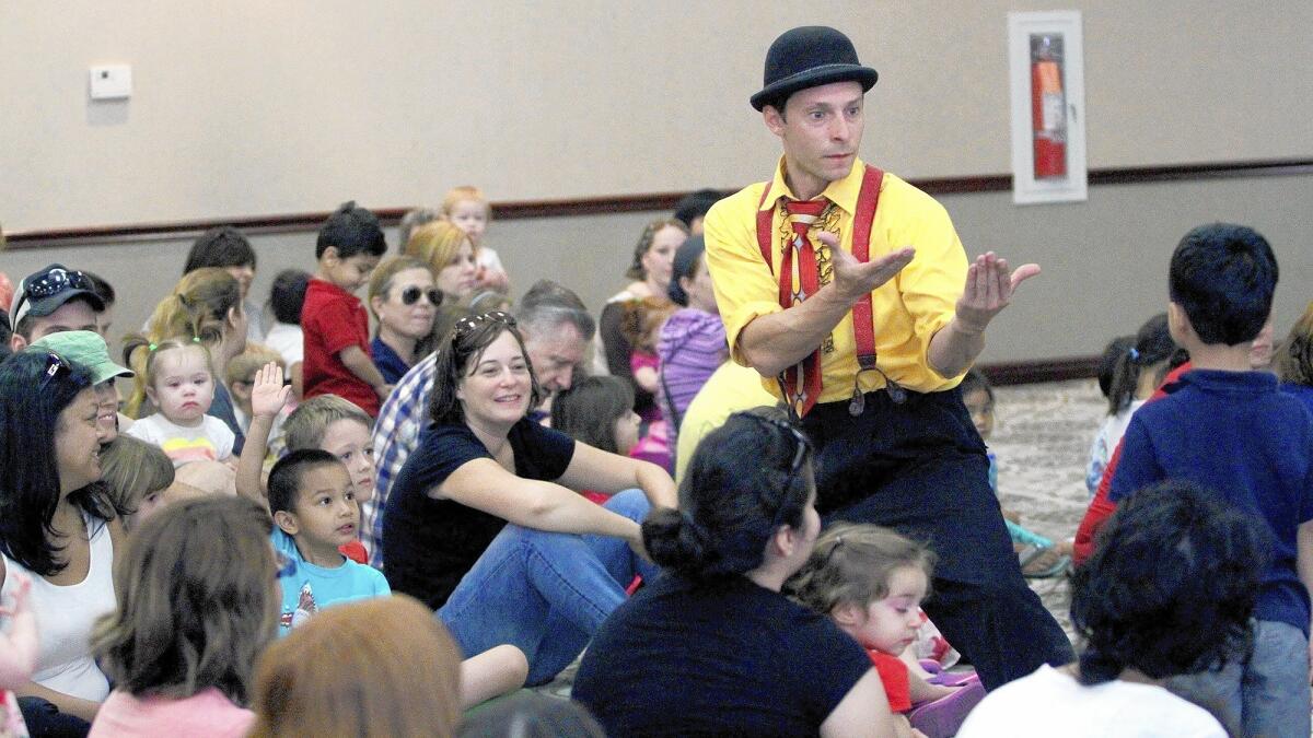 Chris Grabher calls an audience member to help him in Jumbo Shrimp Circus, a one-man show kicking off the summer reading program for the Burbank Library system on Tuesday, June 17, 2014.